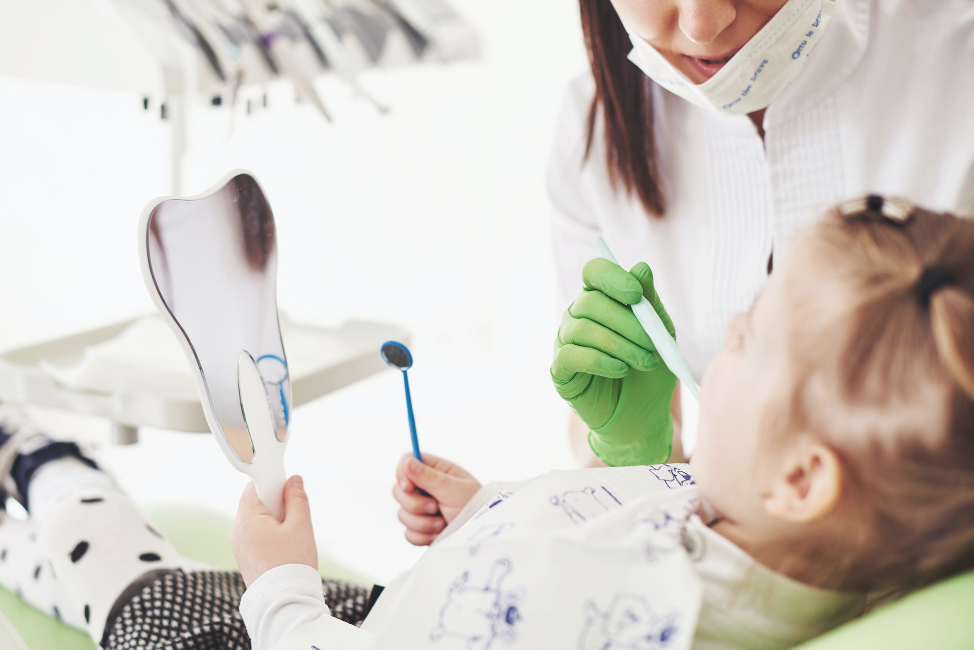Teeth checkup at dentist's office. Dentist examining girls teeth in the dentists chair